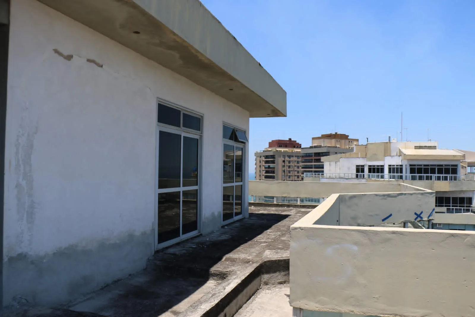 Fachada da cobertura com janelas amplas e vista mar