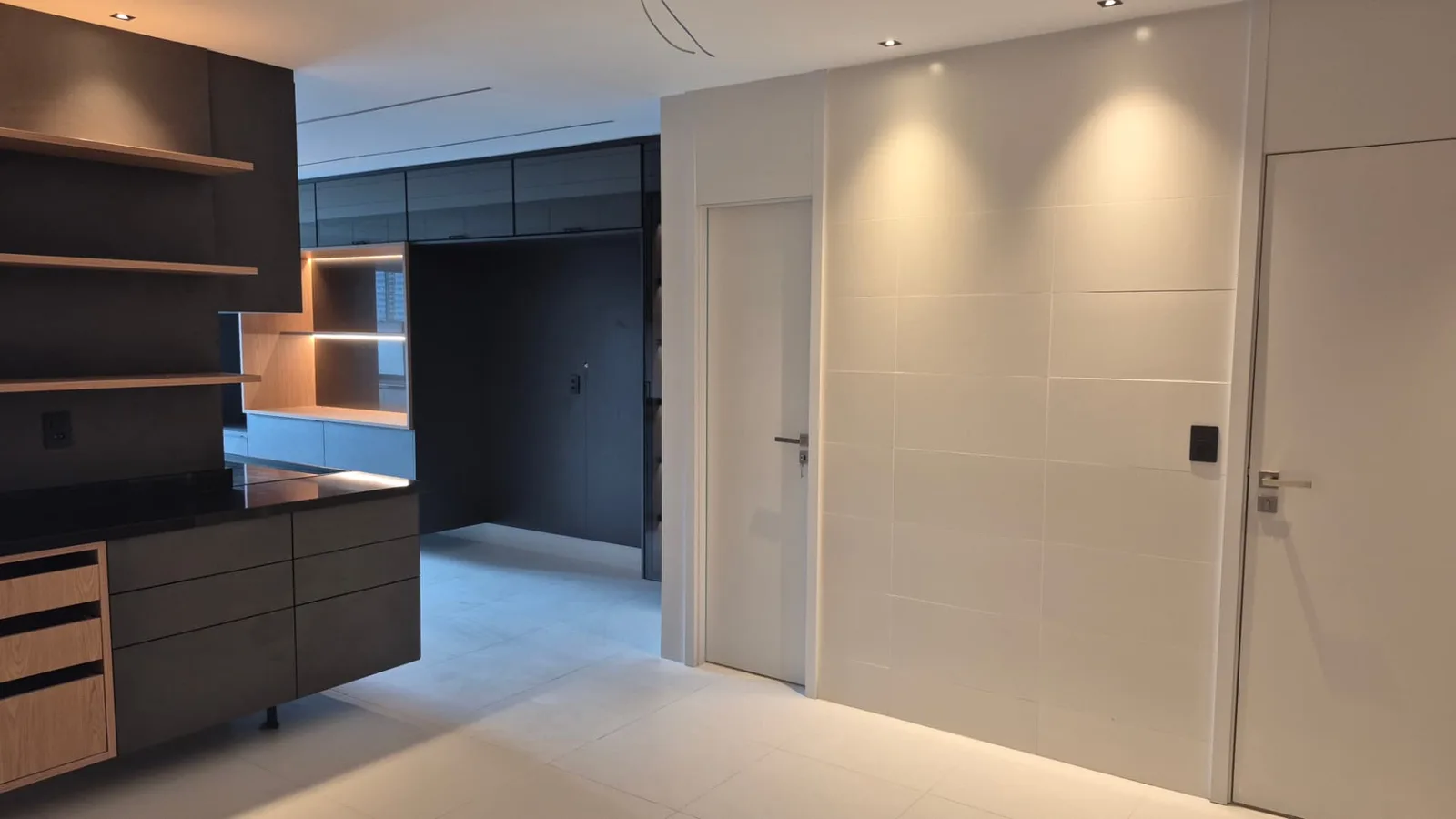 Hall interno com marcenaria sob medida em madeira e laca, iluminação embutida
