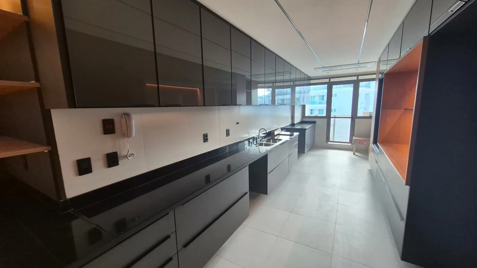 Cozinha em lâmina com armários superiores espelhados e iluminação linear
