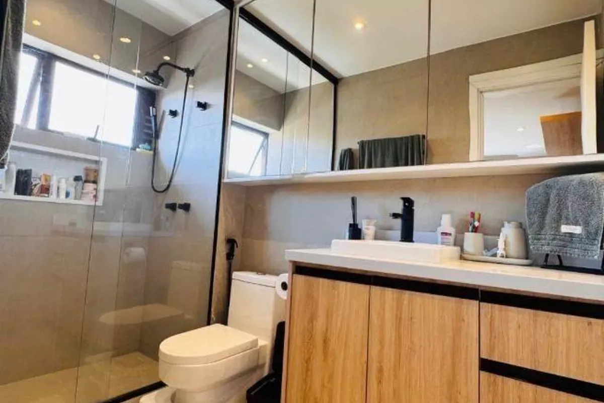 Banheiro da suíte com acabamento moderno em madeira
