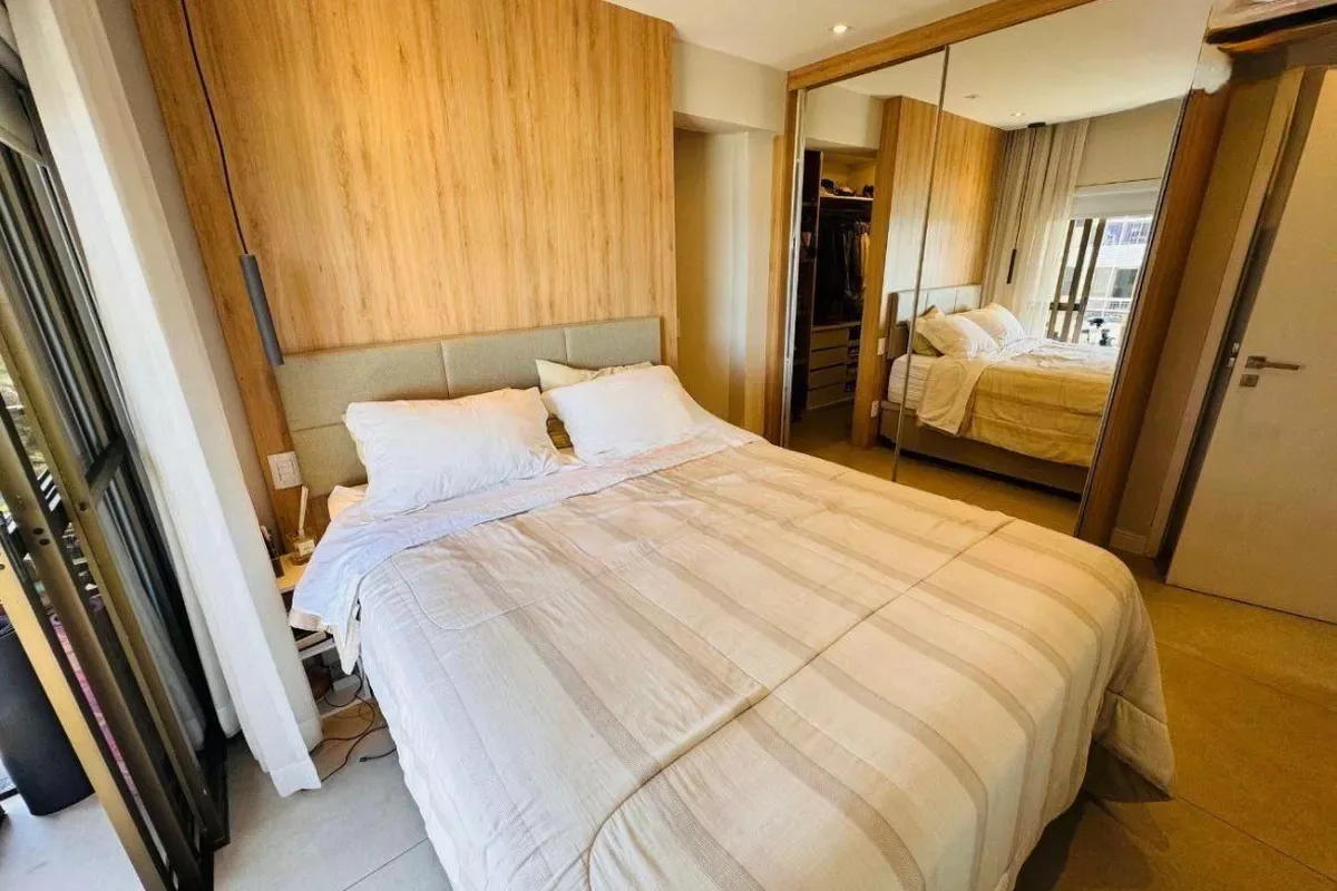 Suíte master com painel em madeira e closet espelhado