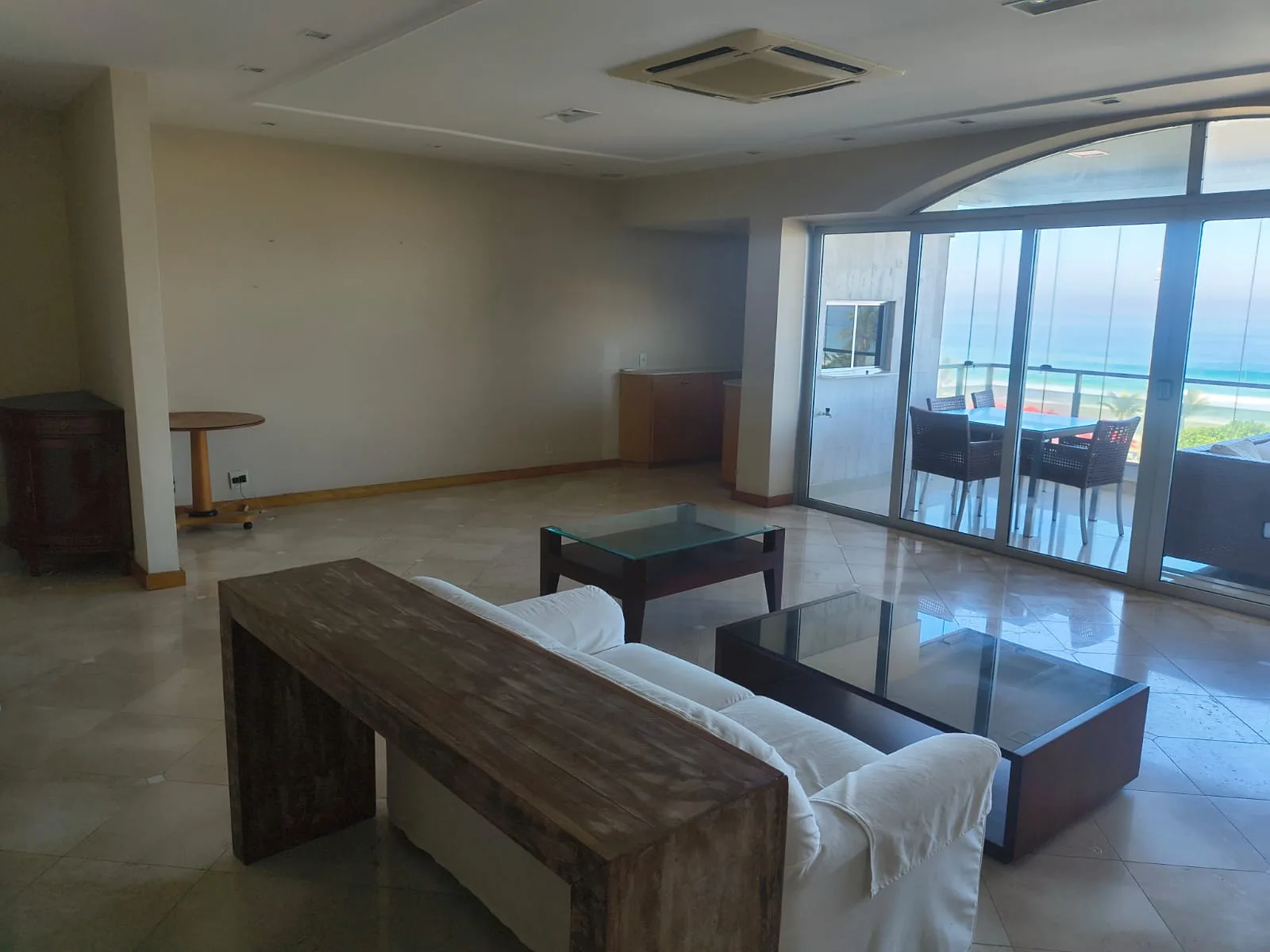Living amplo com integração para o varandão e vista para o mar