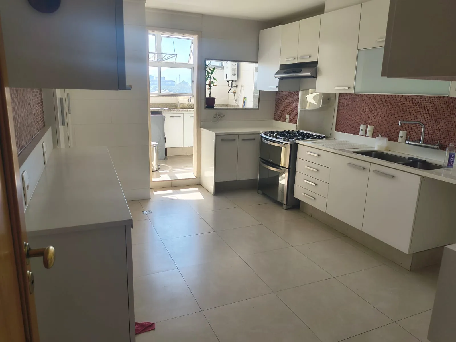 Cozinha planejada com bancadas em mármore e área de serviço integrada