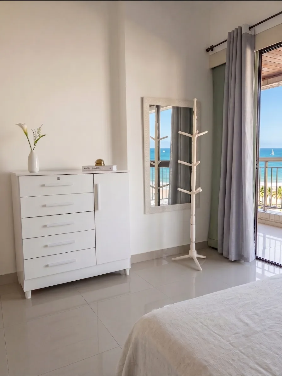 Quarto amplo com cômoda planejada e porta de sacada com vista mar