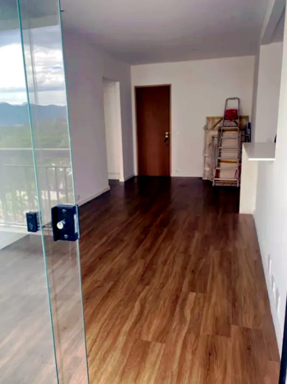 Sala com porta de Blindex e vista montanha