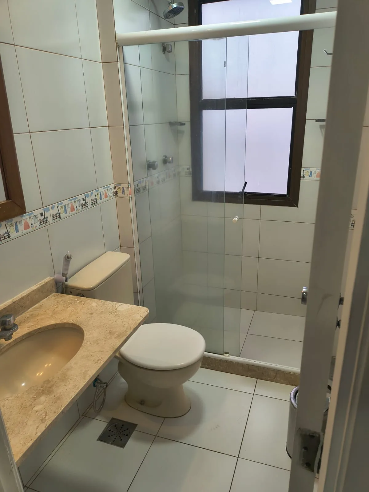 Banheiro da suíte com bancada em mármore no Golden Coast Posto 7 Barra