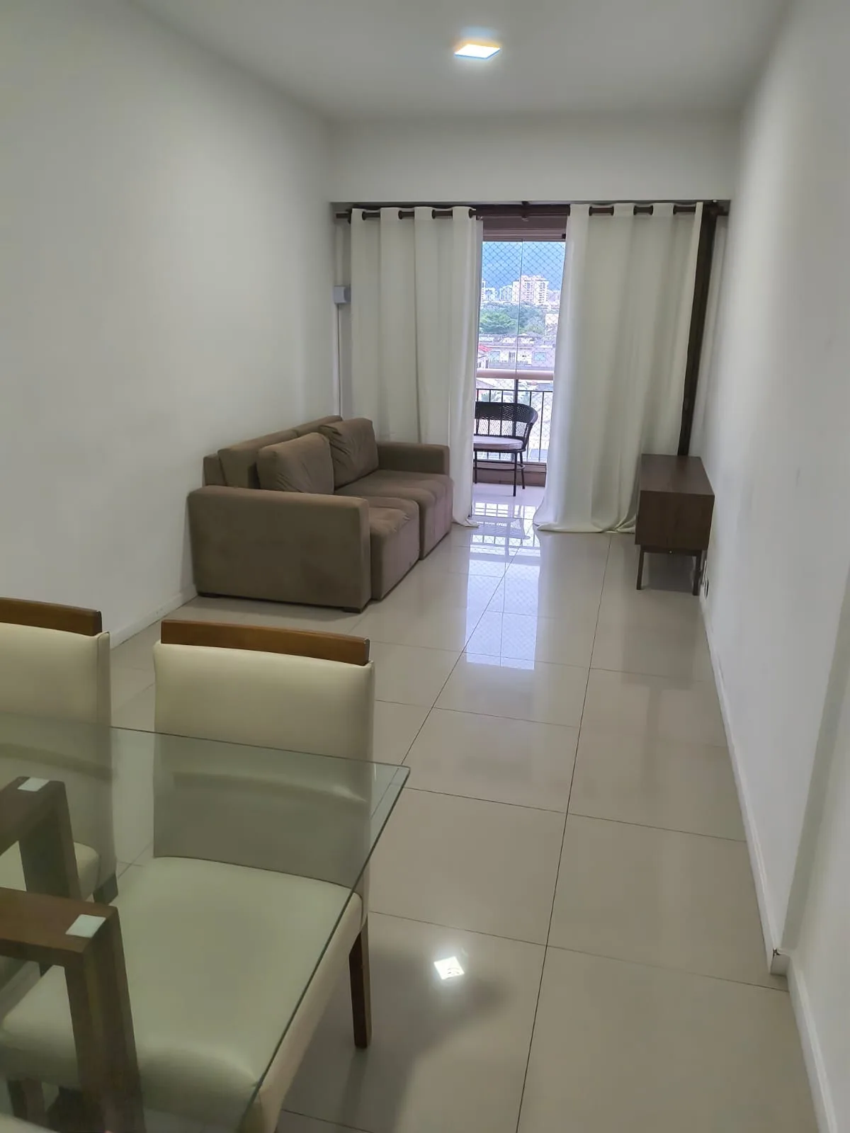 Sala de estar integrada à varanda no apartamento 1 quarto Golden Coast Posto 7 Barra