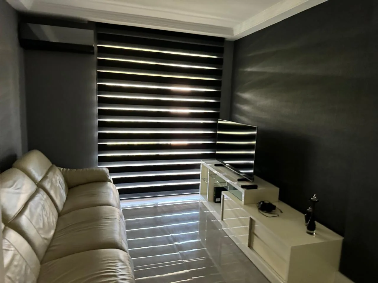 Sala íntima com sofá e TV