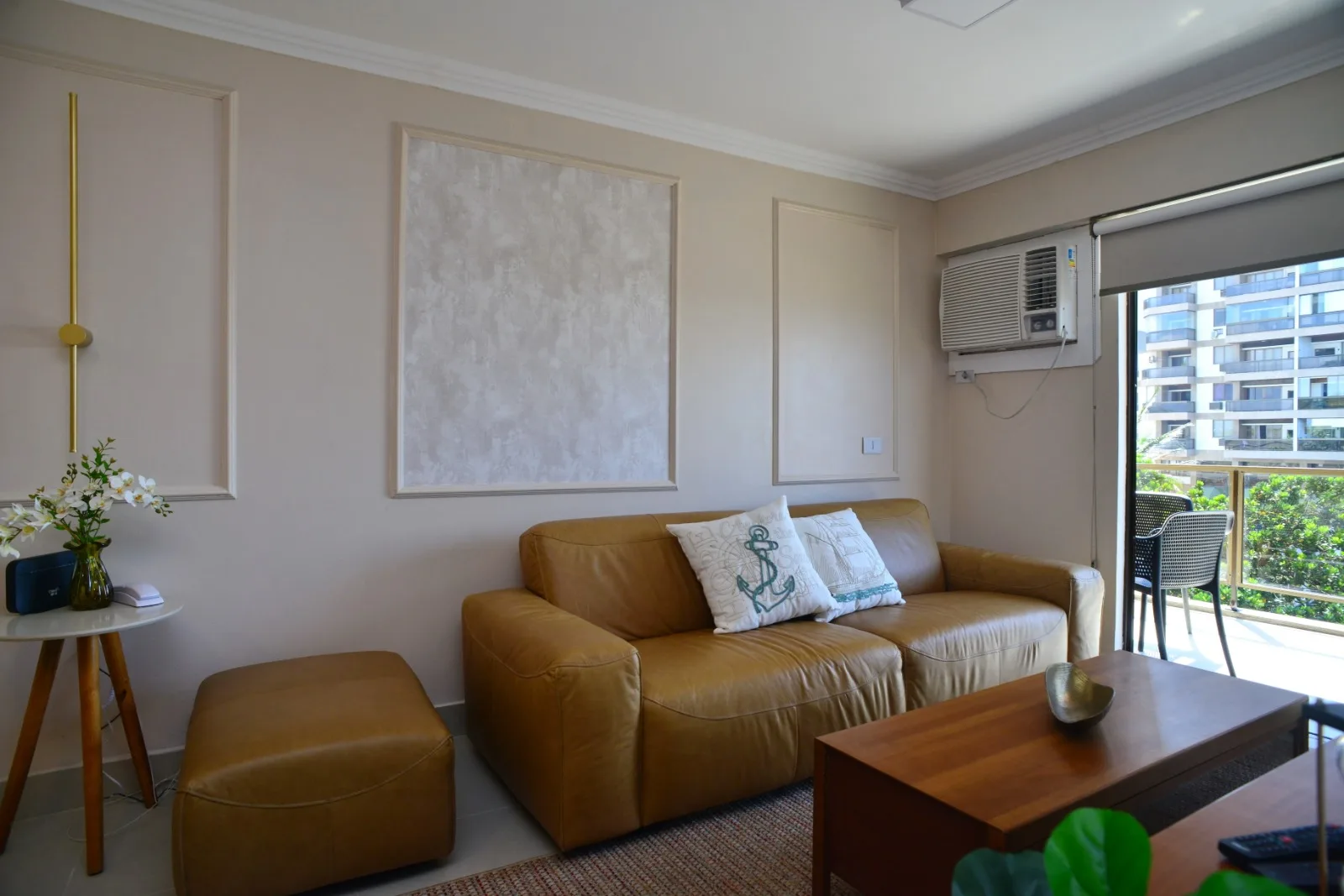 Sala de estar com sofá em couro e varanda