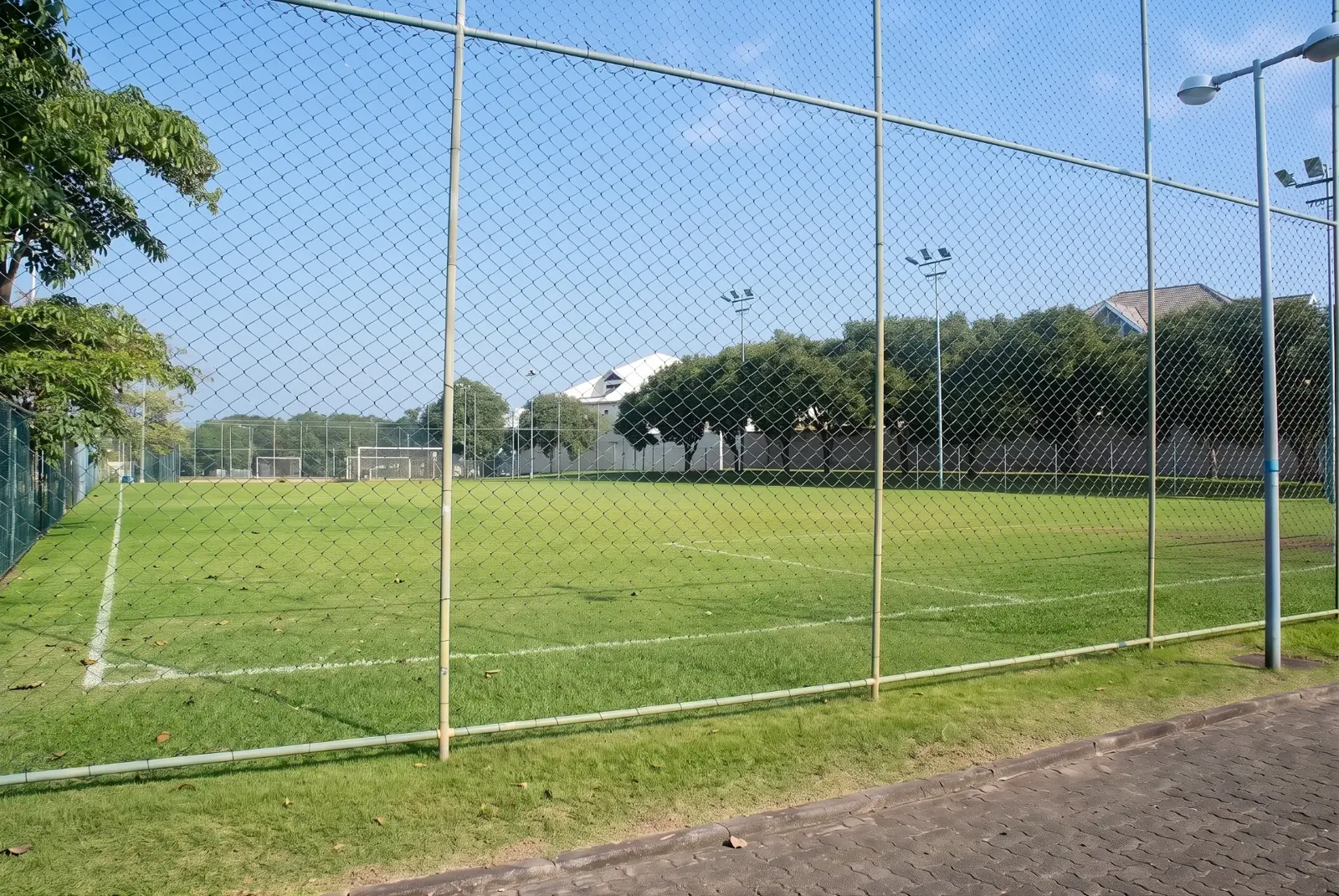 Campo de futebol society com gramado sintético e iluminação no Condomínio Mansões