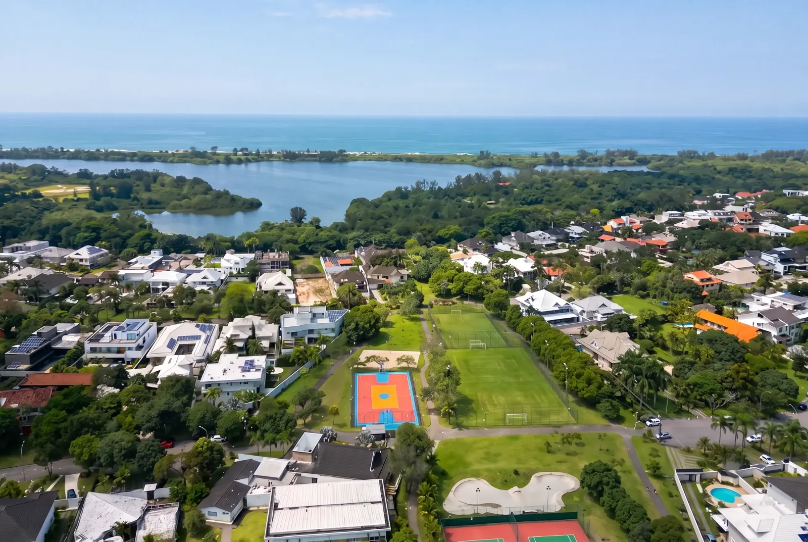 Vista aérea das quadras esportivas do Condomínio Mansões com a Lagoa de Marapendi ao fundo