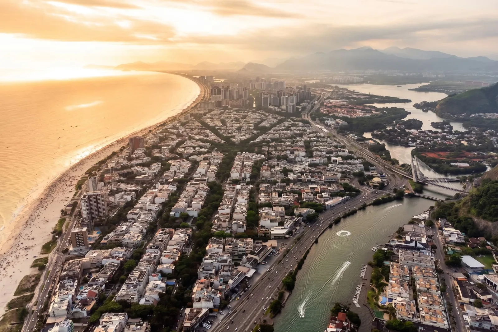 Vista aérea da Barra da Tijuca com a orla, o canal e a Ponte Estaiada próximos ao Condomínio Quintas do Rio